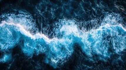 Obraz premium An aerial view of ocean waves crashing, showcasing the vibrant blues and foamy white caps, capturing the beauty and power of nature.
