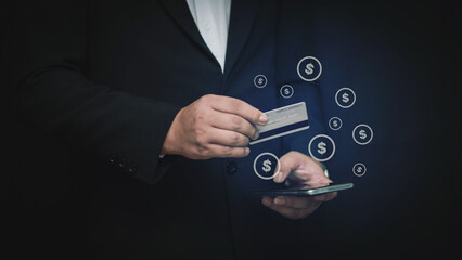 Businessman holding a credit card and smartphone with floating dollar icons, representing online payment, fintech, and digital banking in modern financial transactions.