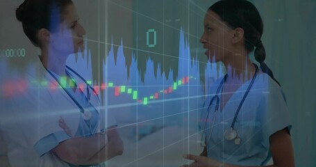 Two female medical professionals discussing data in hospital corridor, showing candlestick chart - Powered by Adobe