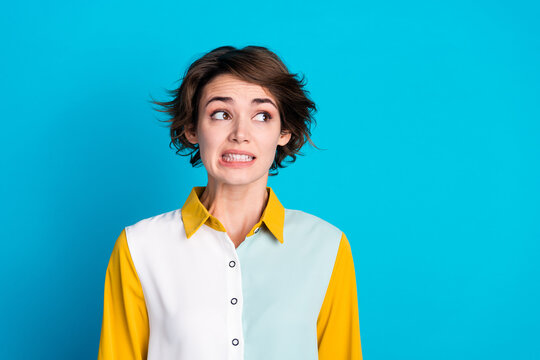Photo of doubtful unsure lady dressed shirt looking empty space feeling guilty isolated blue color background
