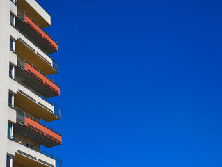 Modern apartment building balconies reaching for the deep blue sky copy space