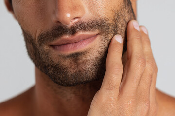 Obraz premium Close-Up of a Man Touching His Well-Groomed Facial Beard with Soft Skin Care