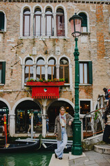 A young woman walks through Venice, on the bridge