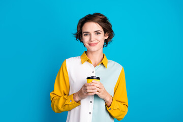 Photo of positive girl hold paper cup with aromatic cappuccino for start working day isolated blue...