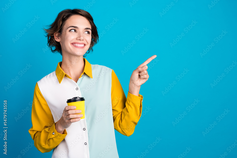 Poster photo of positive attractive girl demonstrate empty space with takeout mocha latte isolated blue col