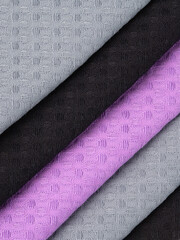 cotton waffle towels for the kitchen hang on hooks on a bracket against a white wall background