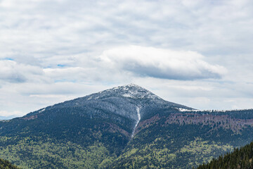 the mountain top is covered with the first snow