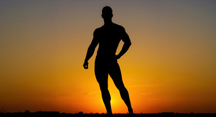 Silhouette of athletic man standing against vibrant orange sunset sky. Fitness lifestyle concept for sports motivation campaigns and wellness program promotion