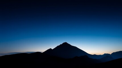 Fototapeta premium Mountain silhouette under twilight sky, serene blue tones blending into dusk, nature's quiet grandeur 