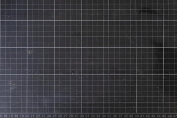 High-resolution image of a dark grey cutting mat with a grid pattern. Ideal for backgrounds or...