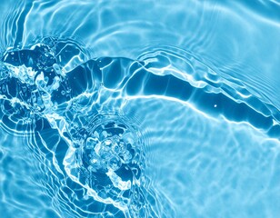 Blue water with ripples on the surface. Defocus blurred transparent blue colored clear calm water surface texture with splashes and bubbles. Swimming pool top view close up.