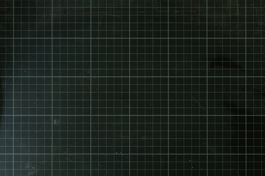 High-resolution image of a dark green cutting mat with a grid pattern. Perfect for backgrounds or textures.