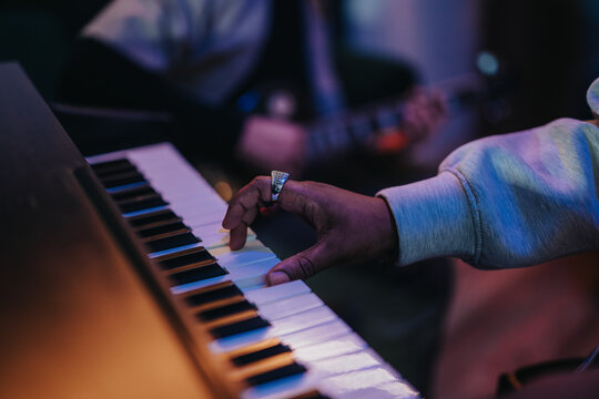 An expressive shot of a musician skillfully playing piano keys. The image captures the essence of performance with a focus on musical creativity and emotion in a live setting.