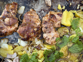 Delicious grilled chicken breast served with roasted potatoes, onions, and a vibrant chimichurri sauce.