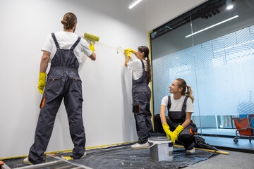 Group of housekeeping staff painting the walls in the office
