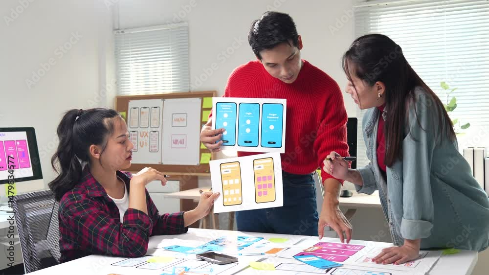 Poster two young asian ux web designers working on app interface developing prototype wireframe discussing 