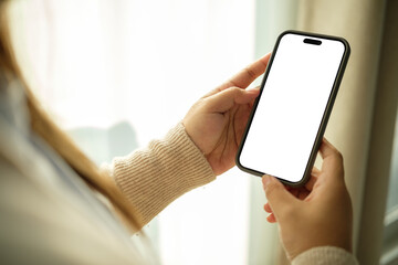 Hands holding smartphone with empty white screen, perfect for UI design or app mockup presentations.