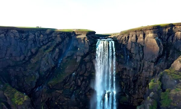 Aerial view of the flow of water falling from the volcanic cliffs
