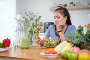 Young woman looks unhappy while holding a fork with salad, showing dislike for healthy food.