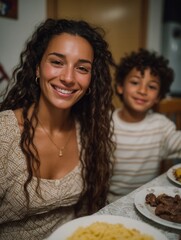 Happy woman and young boy enjoying dinner with food on table at home