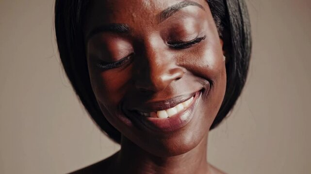 Close-up video shot of a woman's face, capturing intense expression. Neutral background, straight-on camera angle emphasizes her features.