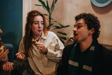 Friends enjoy their time together in a cozy environment, sharing laughter and snacks. The atmosphere reflects casual interaction and comfort, portraying the warmth of relationships and shared moments.