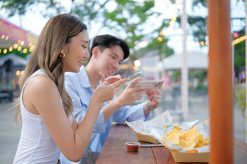 Relaxed travelers having fun while dining al fresco at a vibrant street food stall.