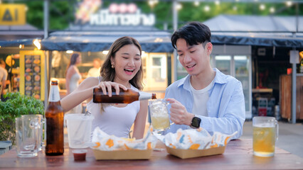 Travel lifestyle moment with couple sharing drinks and snacks in a casual food court setting.
