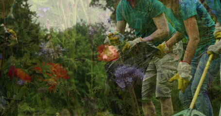 Image of flowers over diverse group of people collecting rubbish in forest