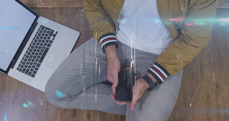 Image of shapes over midsection of caucasian man using laptop and smartphone with copy space