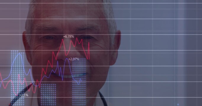 Image of financial graphs over happy senior caucasian male doctor looking at camera