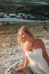 a woman in a white dress, a bride on a mountain with a blue sky. Beautiful nature, freedom, enjoyment of life. High quality photo