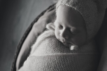 A newborn baby is wrapped in diapers with a wool cap in a basket. Swaddling, maternity hospital, family, ivf, life planning, parenting. A mother's love for her child. Baby food. High quality photo