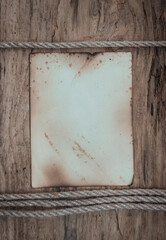 Vintage old paper with rope on the weathered wooden background