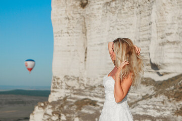 a woman in a white dress, a bride on a mountain with a blue sky. Beautiful nature, freedom, enjoyment of life. High quality photo