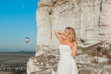 a woman in a white dress, a bride on a mountain with a blue sky. Beautiful nature, freedom, enjoyment of life. High quality photo