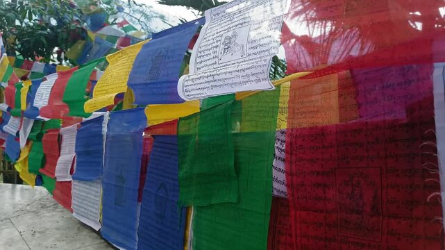Colorful Buddhist prayer flags fluttering in the wind around a serene temple 