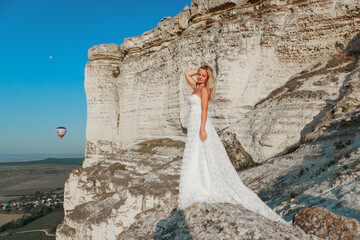 a woman in a white dress, a bride on a mountain with a blue sky. Beautiful nature, freedom, enjoyment of life. High quality photo