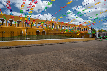 Colorful flags and the yellow Convento de San Antonio in Izamal, Yucatan, Mexico