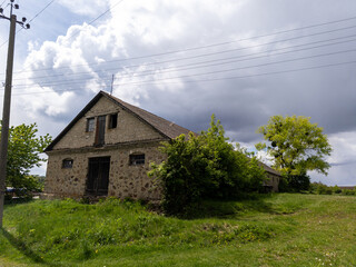 Fototapeta premium An old stone building sitting in the middle of a grassy field