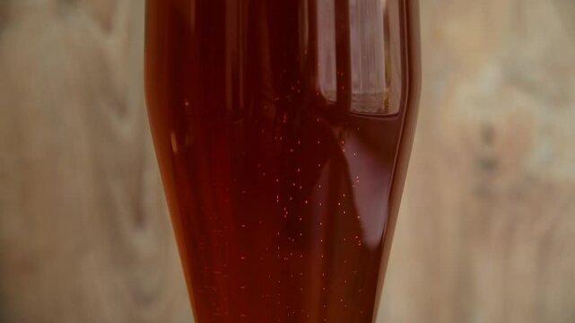 Enjoying a refreshing glass of amber beer against a rustic backdrop