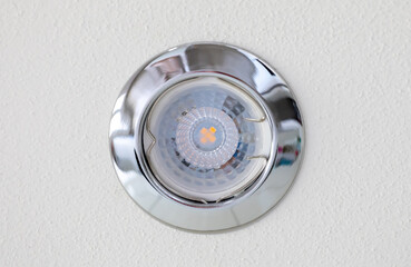 Modern led spotlight illuminating white textured ceiling