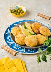 Fish cutlets from white sea fish in golden breading in a ceramic plate on a light concrete background. Recipes fish, seafood.