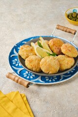 Fish cutlets from white sea fish in golden breading in a ceramic plate on a light concrete background. Recipes fish, seafood.