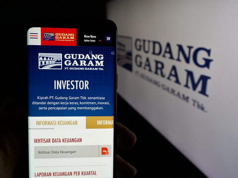 Stuttgart, Germany - 05-02-2025: Person holding smartphone with website of Indonesian tobacco company Gudang Garam on screen in front of logo. Focus on center of phone display.