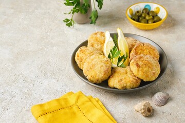 Fish cutlets from white sea fish in golden breading in a ceramic plate on a light concrete background. Recipes fish, seafood.