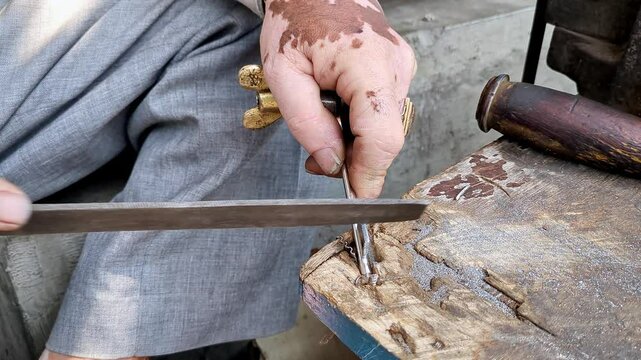 Top close-up shot of an Indian locksmith manually making a duplicate house key.manual key making