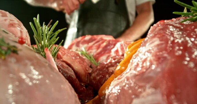 Super Slow Motion of Butcher Hitting the Raw Meat by Cleaver. Filmed on High Speed Cinema Camera.  Meat Preparation Concept, Fire on Background. Camera Placed on Motion Control System.