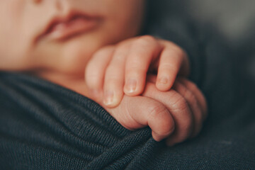 A newborn baby in diapers. A baby in the hands of a mother, maternal love, family, childbirth, having many children. Children's clothes, booties. High quality photo