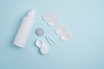 Contact lenses, case and bottle with solution and eye drops on white background. Eye health and care, vision, ophthalmology concept, close-up 